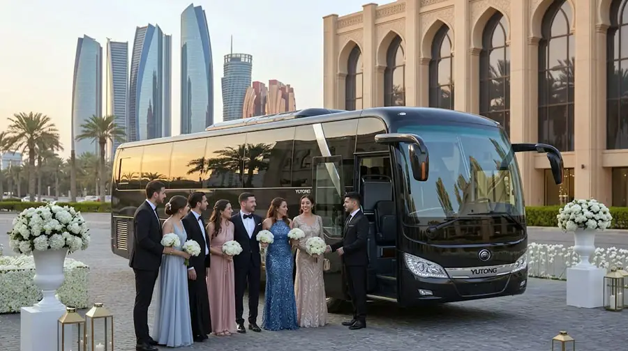 Wedding party boarding a black luxury Yutong coach with Abu Dhabi skyline in the background for group bridal transport.