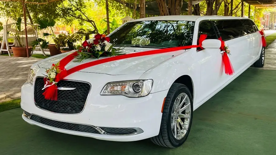 White stretch limousine decorated with red ribbons and flowers for wedding hire in Abu Dhabi.