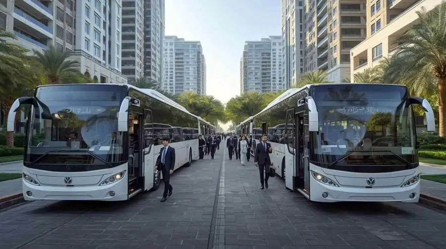 Modern staff buses with employees boarding near office towers in Abu Dhabi’s business area.